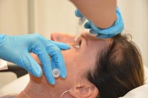A woman being given eye drops